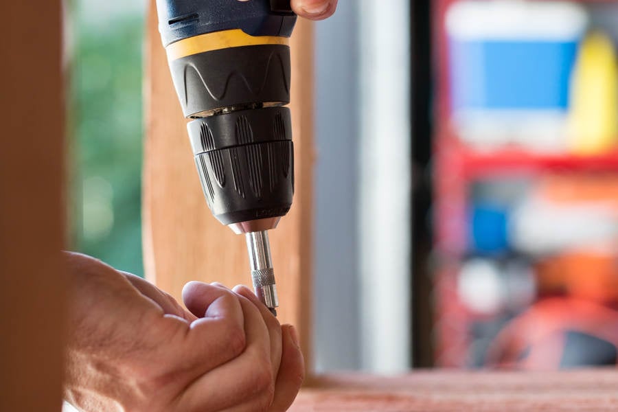 Close-Up of a Handyman Using an Electric Screwdriver in his Workshop