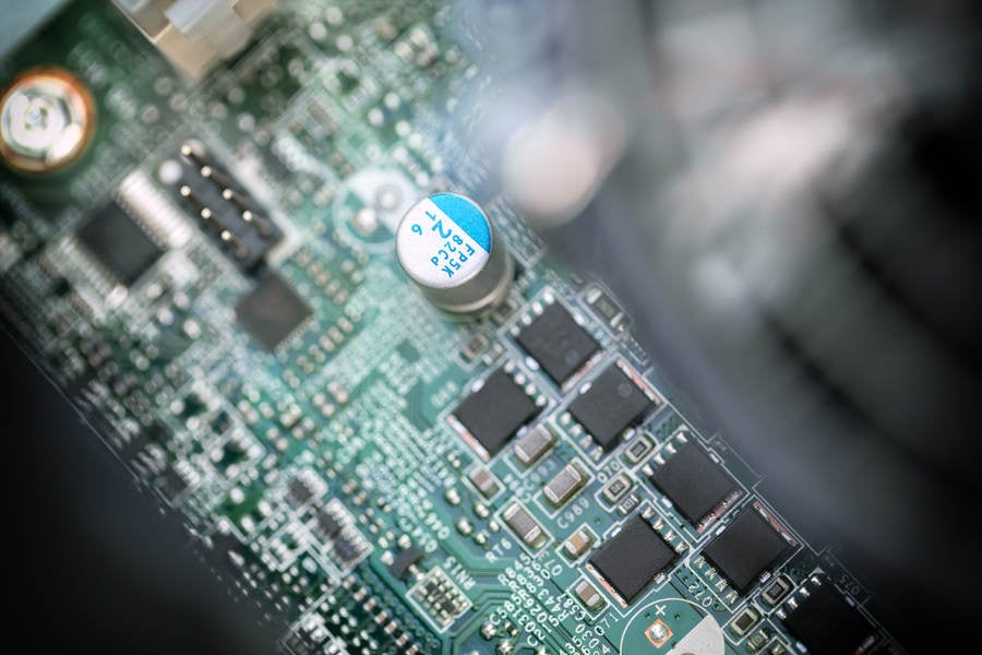Close-Up View of a Circuit Board with a Blurred CPU Fan in Foreground