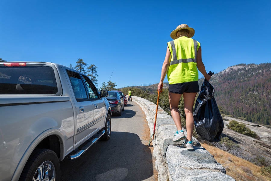 A Cleanup Volunteers Looking for Litter by a Road