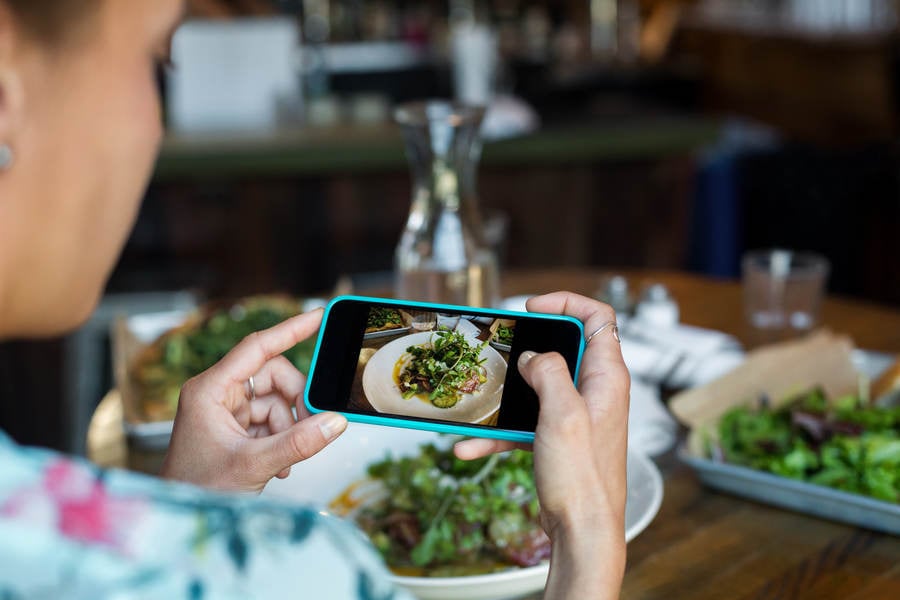 Woman Taking Picture of Her Meal with a Smartphone