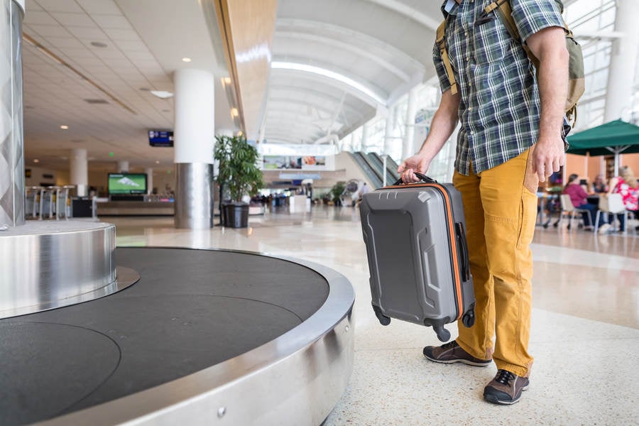 Traveler Unloading a Suitcase from a Luggage Carrousel
