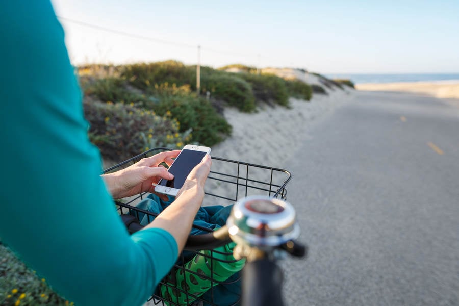 Girl on a Cruiser Bike on a Coast Bike Path Texting on Her Phone