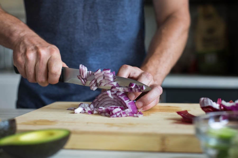 Hands of a Man Cutting a Red Onion for Guacamole