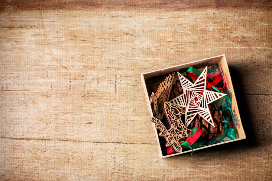 High-Angle View of Tree Ornaments in a Box Placed on a Wooden Table