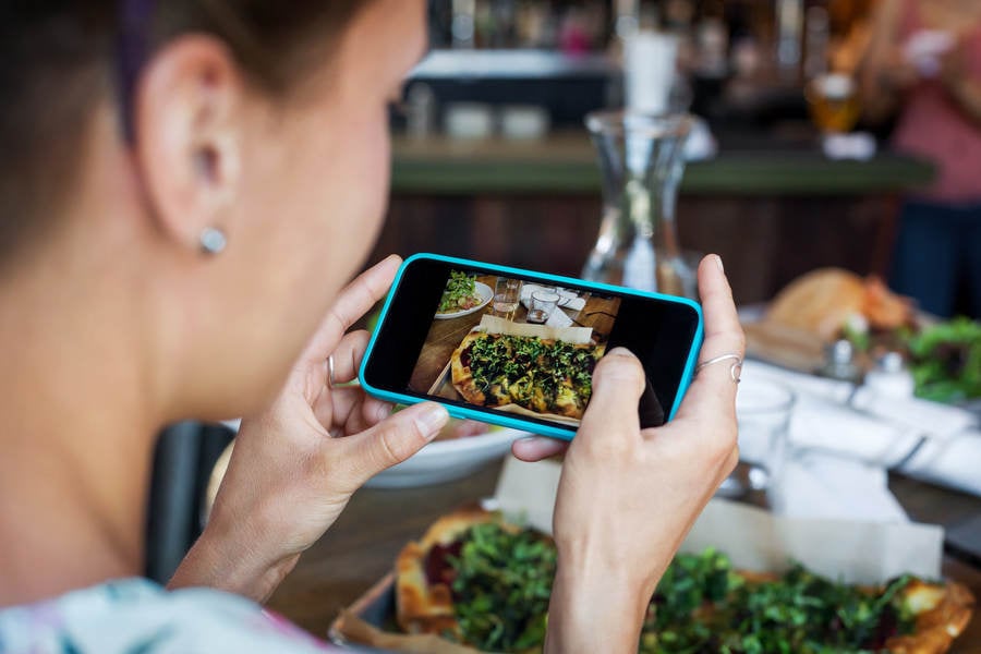 Woman Taking Picture of Her Meal with a Camera Phone
