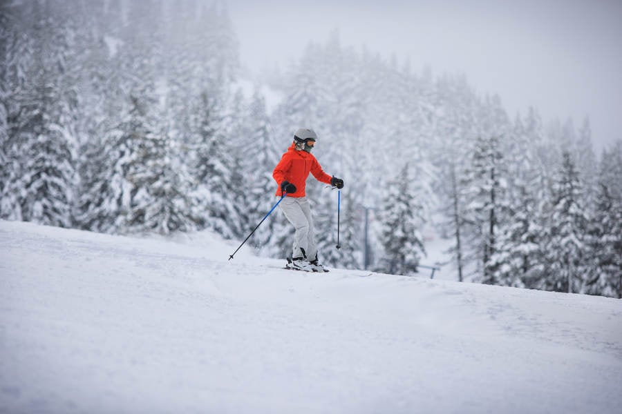 Female Skier in a Red Jacket in Slightly Whiteout Conditions