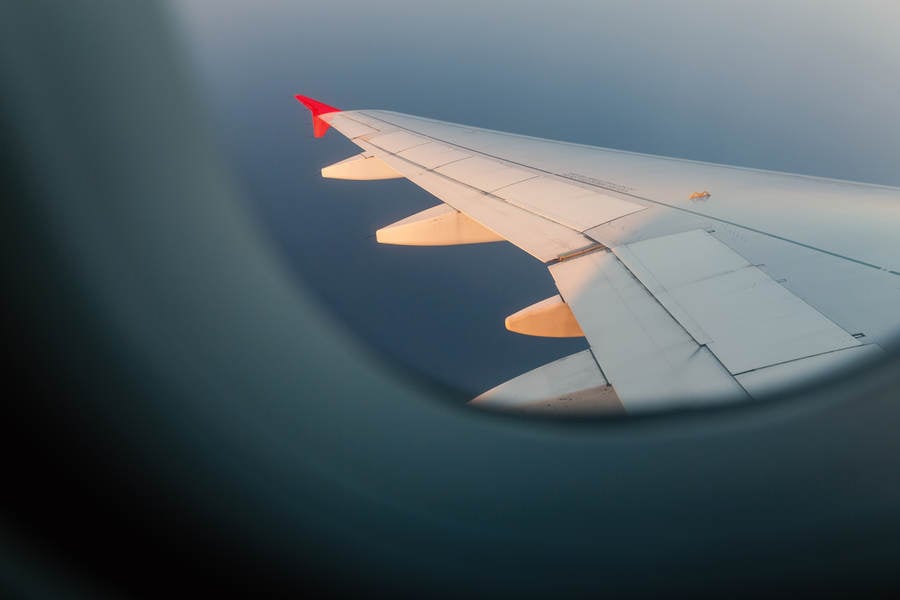 Airplane Wing Illuminated by Setting Sun Seen Through a Window
