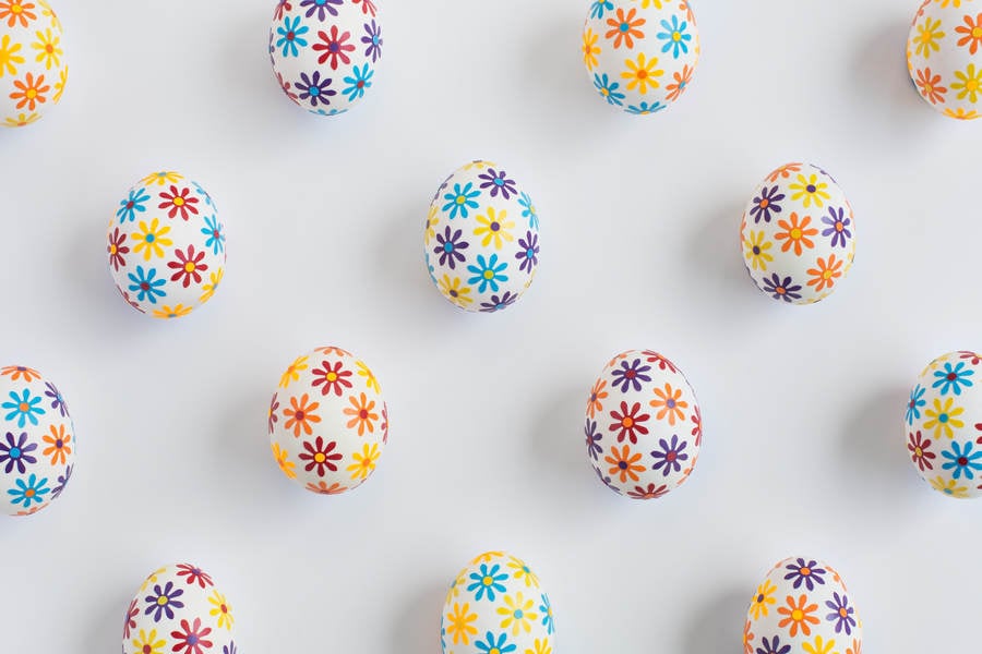 Easter Eggs Decorated with Flower Petal Stickers Arranged on a White Background