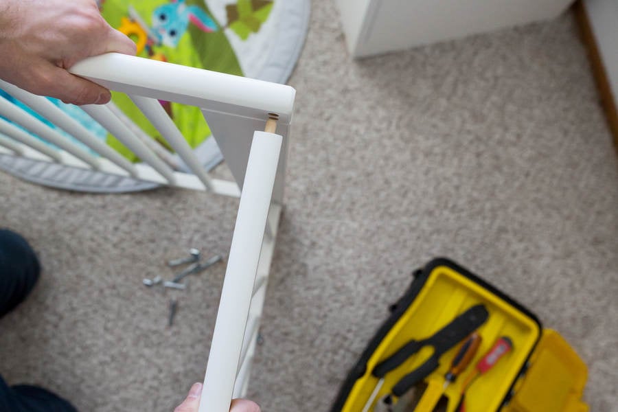 Overhead View of a Man Assembling a Baby Crib in a Children's Room