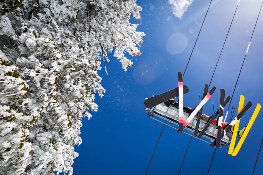 Straight-Up View of Skiers Going up on a Ski Lift