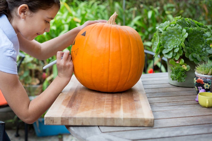 Young Girl Drawing on a Pumpkin Prior Carving