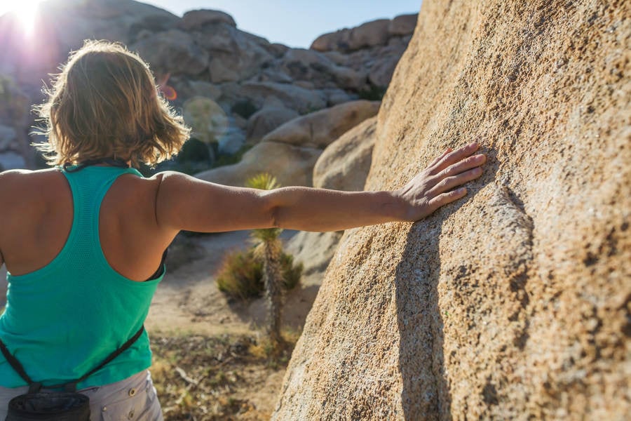 Young Woman Stretching Prior an Outdoor Bouldering Session