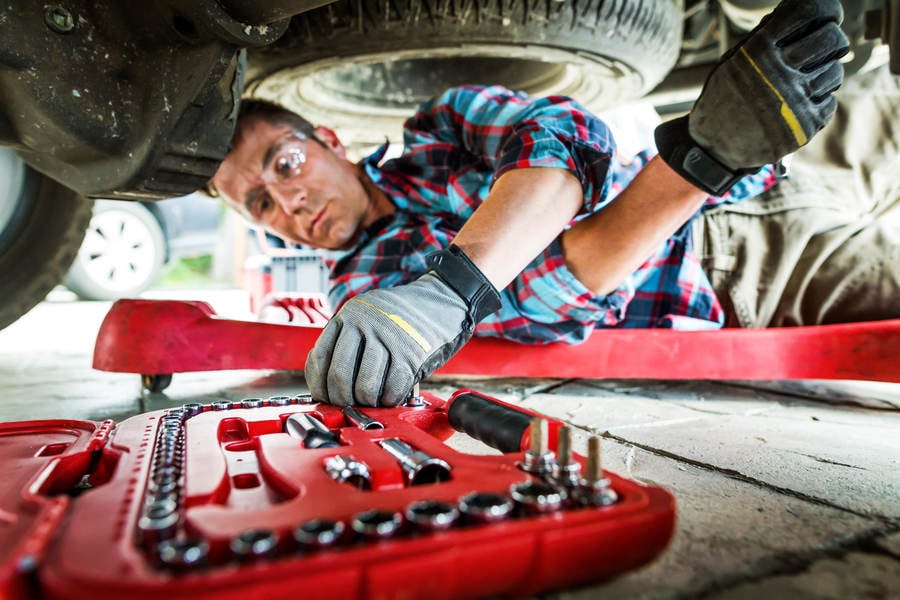 Car Mechanic Reaching for a Socket Wrench from a Tool Box
