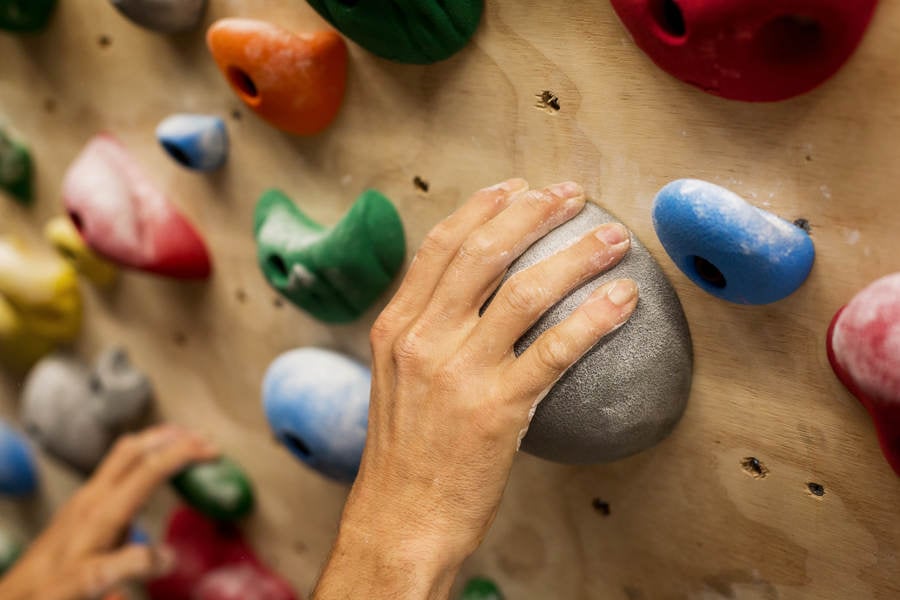 Man's Hand Gripping a Sloper Hold on a Practice Wall at Home