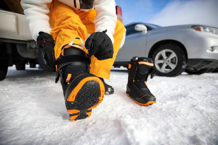 Low-Angle View of a Man Putting on Snowboarding Boots