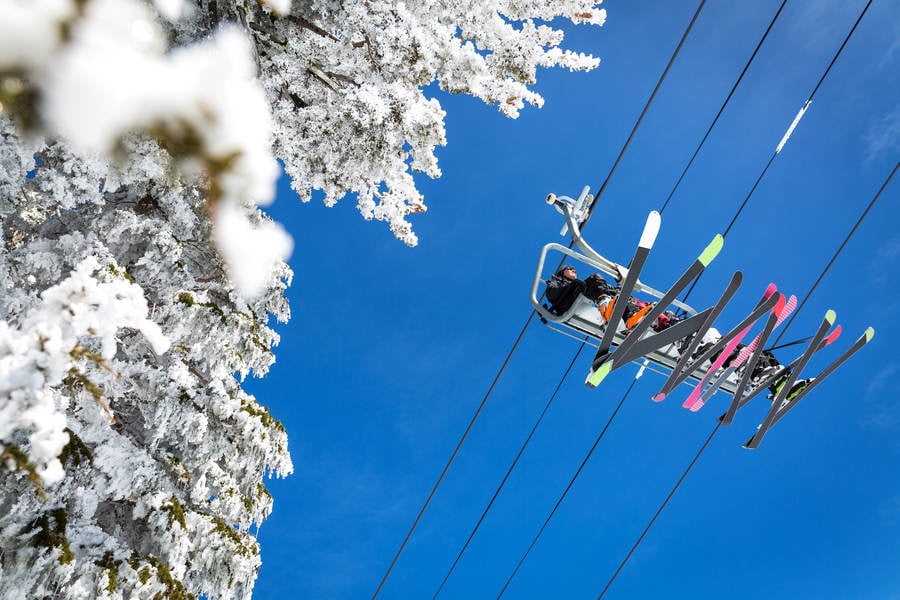 Straight-Up View of Skiers Sitting on a Ski Lift