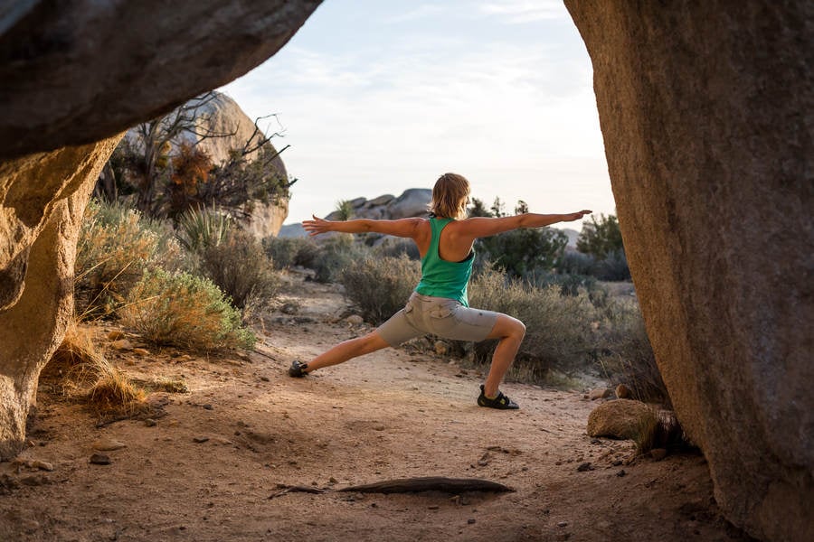 Rear View of a Female Rock Climber Practicing Yoga
