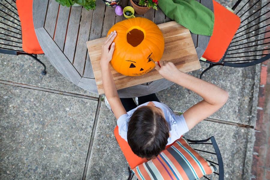 Directly-from-Above View of a Young Girl Carving a Pumpkin