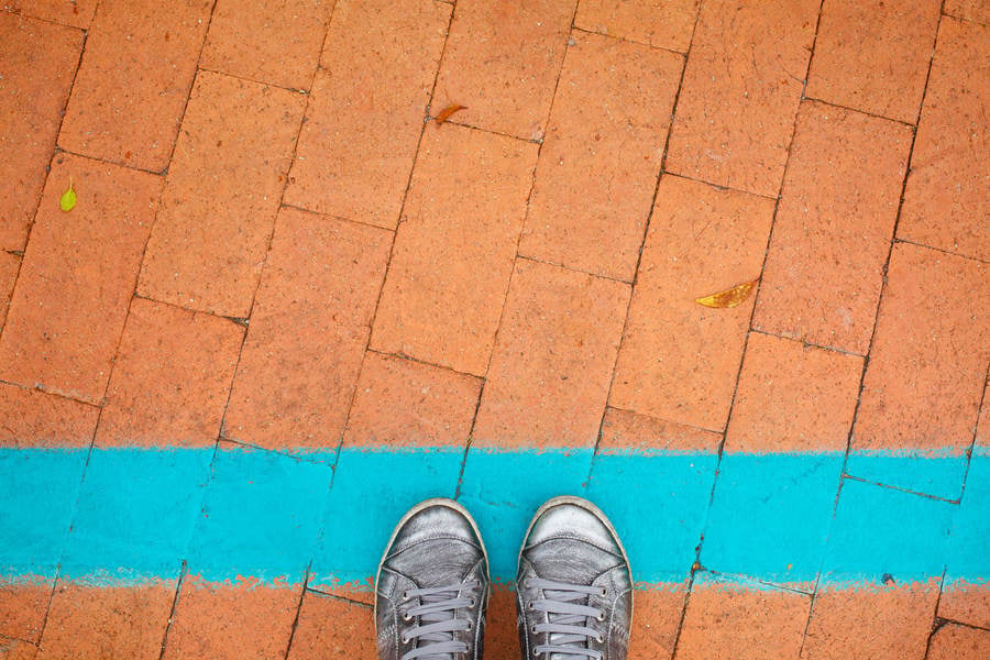 Low Section View of a Woman in Silver Sneakers Standing on a Blue Line