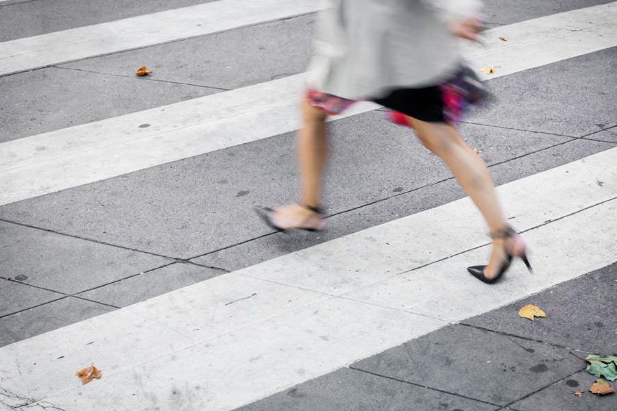 Low Section View of a Businesswoman Crossing a City Street