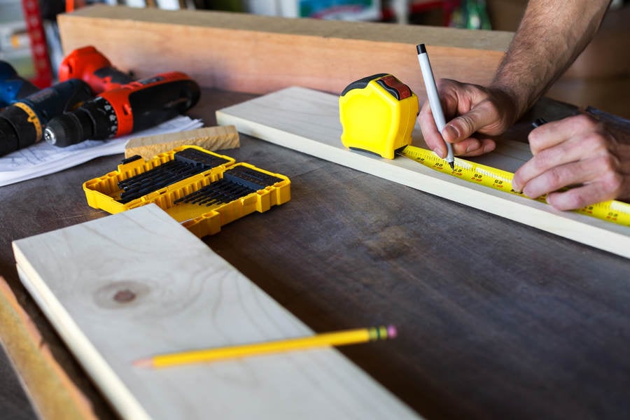 Handyman Using a Measuring Tape for a Woodworking Project