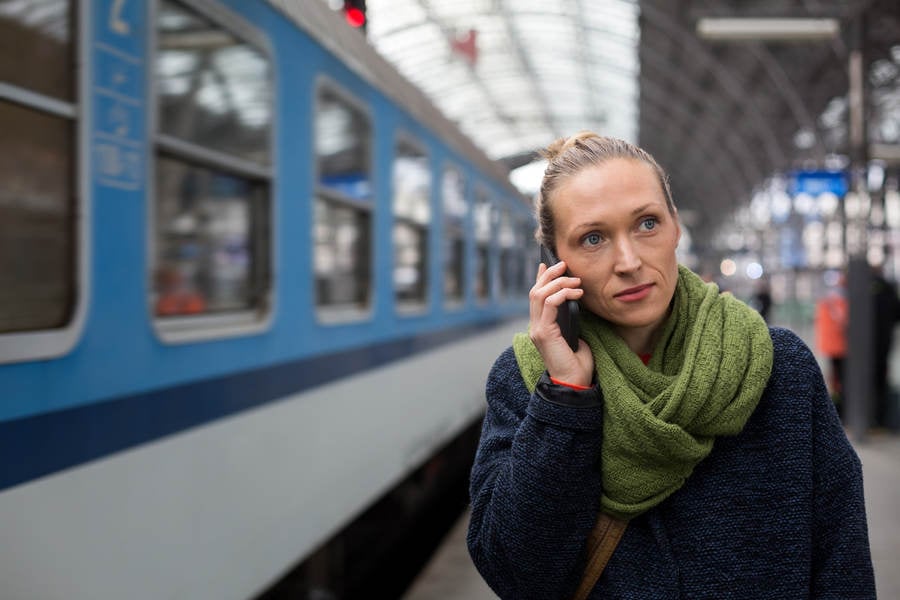 Woman Walking on a Train Station Platform and Making a Phone Call