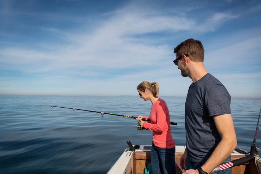 Young Couple Fishing from a Boat in a Calm Ocean