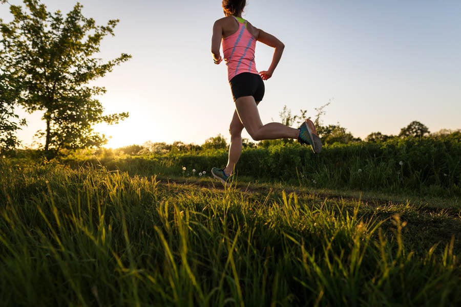 Low-Angle View of a Young Athletic Woman Running During Sunset
