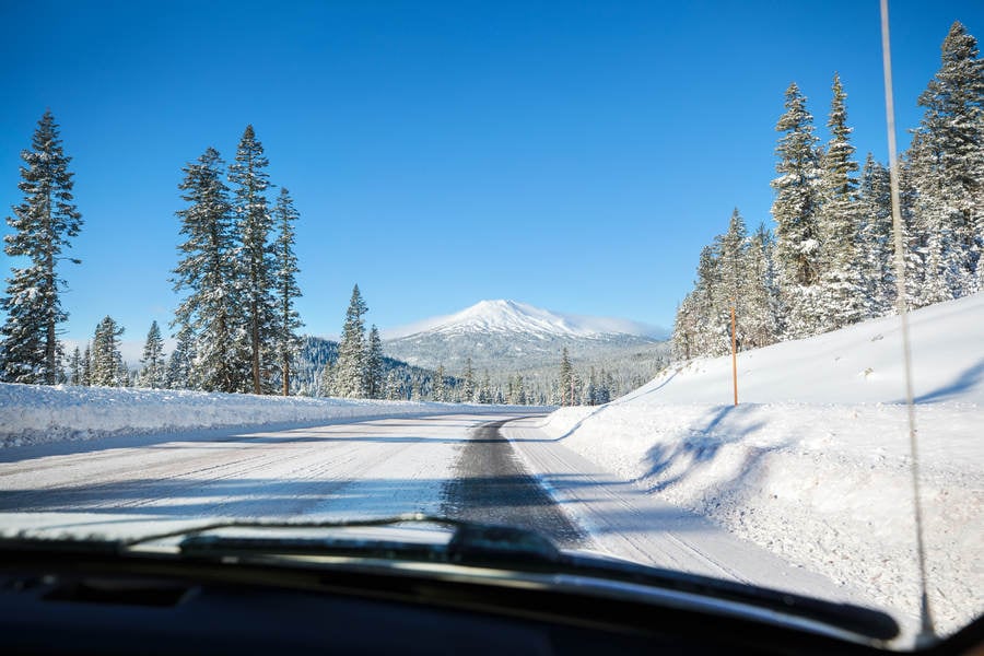 View from a Car Driving Through a Snowy Landscape with Mt. Bachelor in the Background