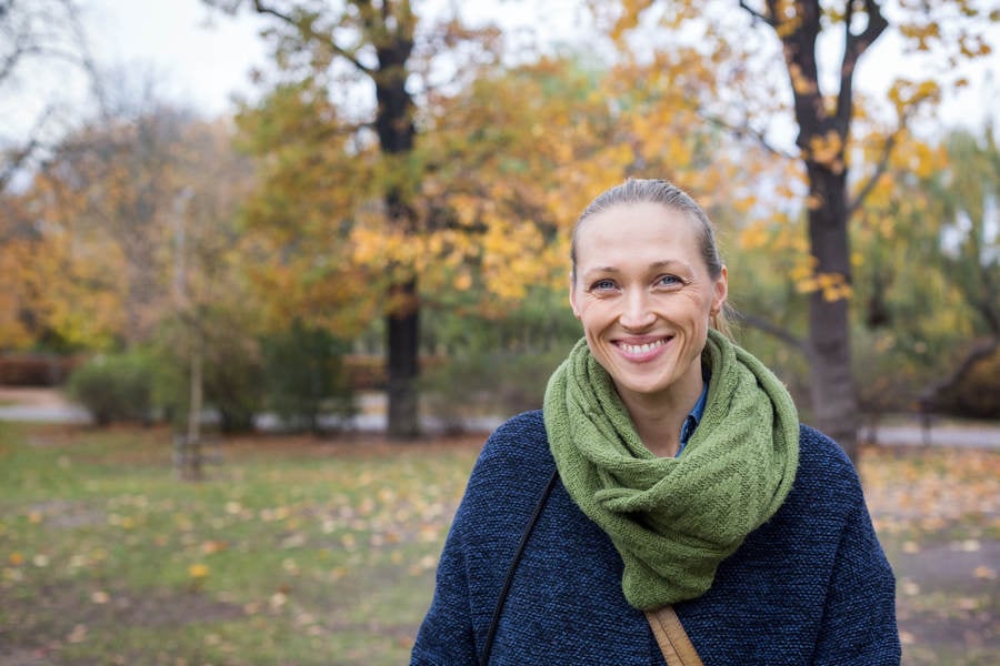 Portrait of a Smiling Woman Standing at a Public Park in Fall