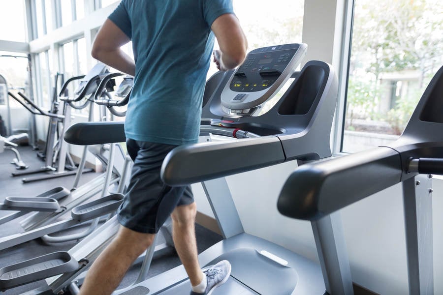 Determined Man Jogging on a Treadmill in a Gym