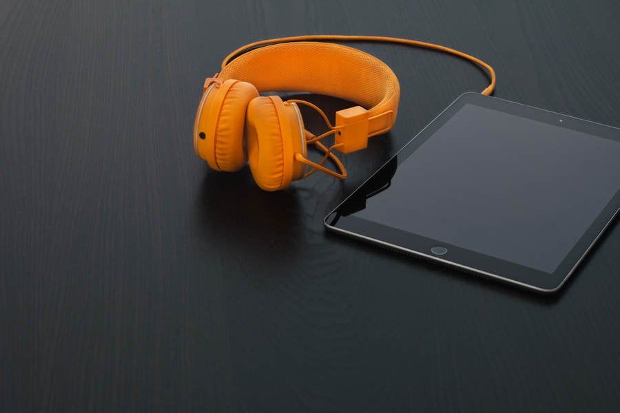 View of a Tablet and Headphones on a Black Table