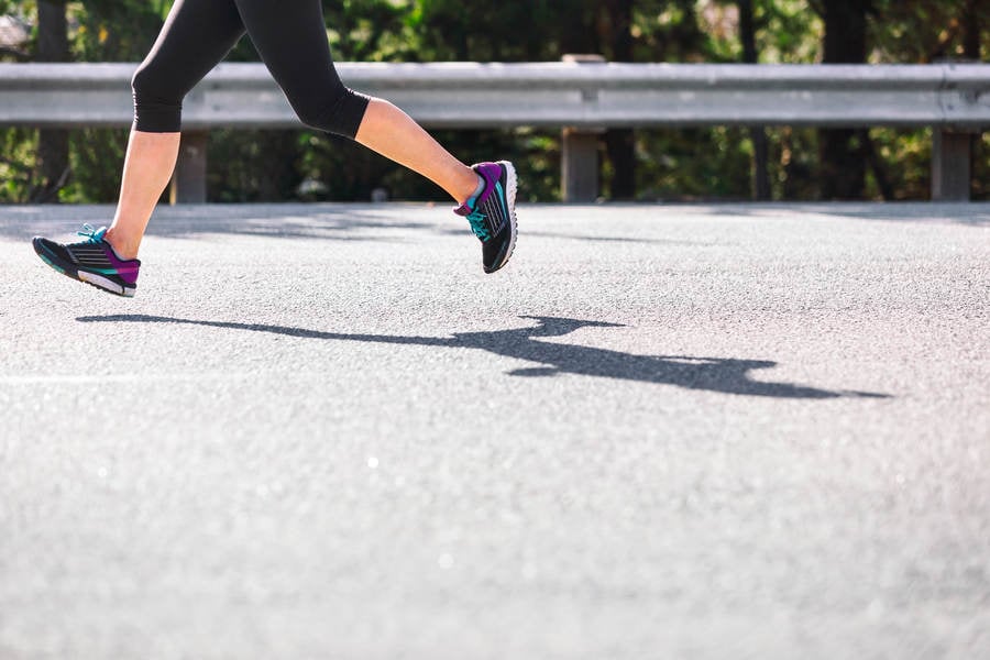 Lower Section of a Runner Running on a Road