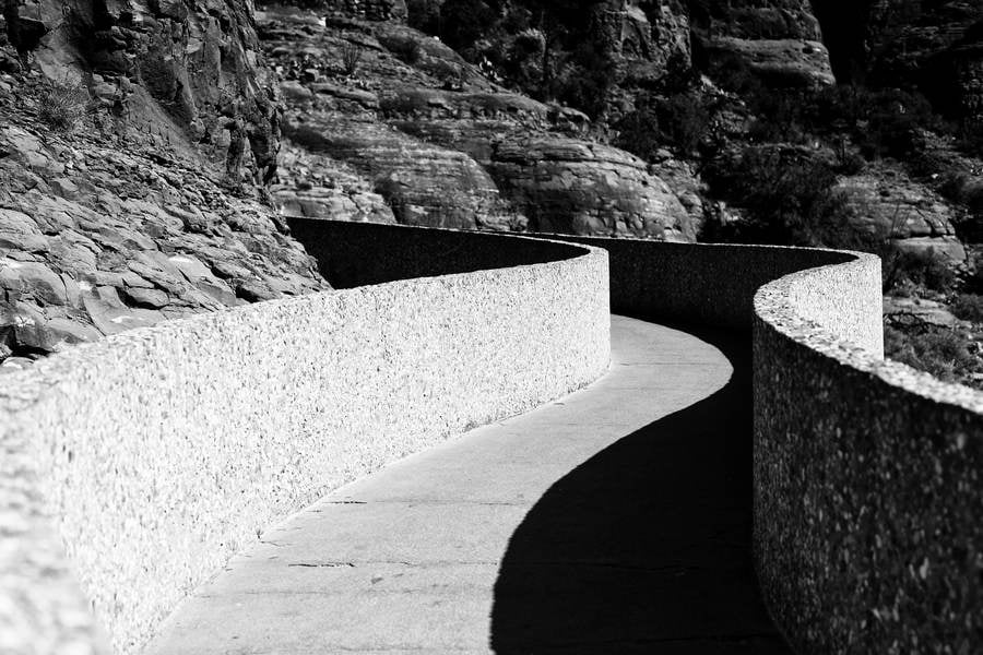 Curved Pathway with a High-Contrast Shadow Cast by Stone Railing