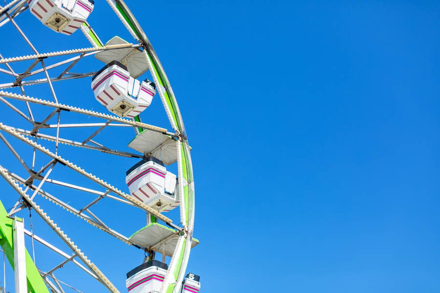 Low-Angle View of a Ferris Wheel Against the Blue Sky