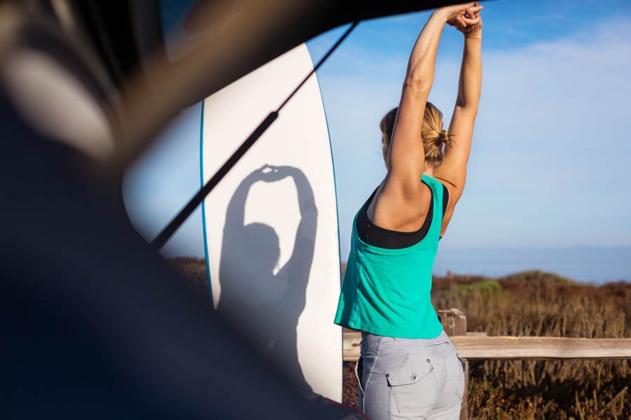 Young Woman Stretching Before a Surf Session