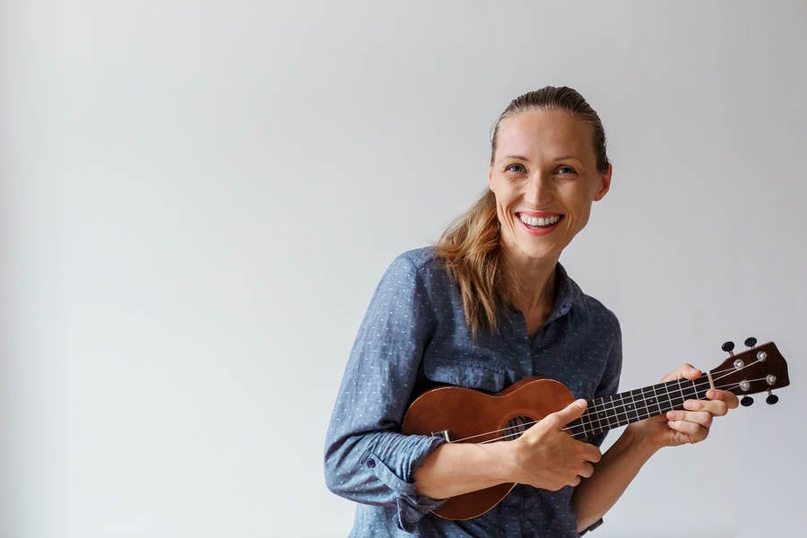 Young Woman Smiling and Playing Ukulele 