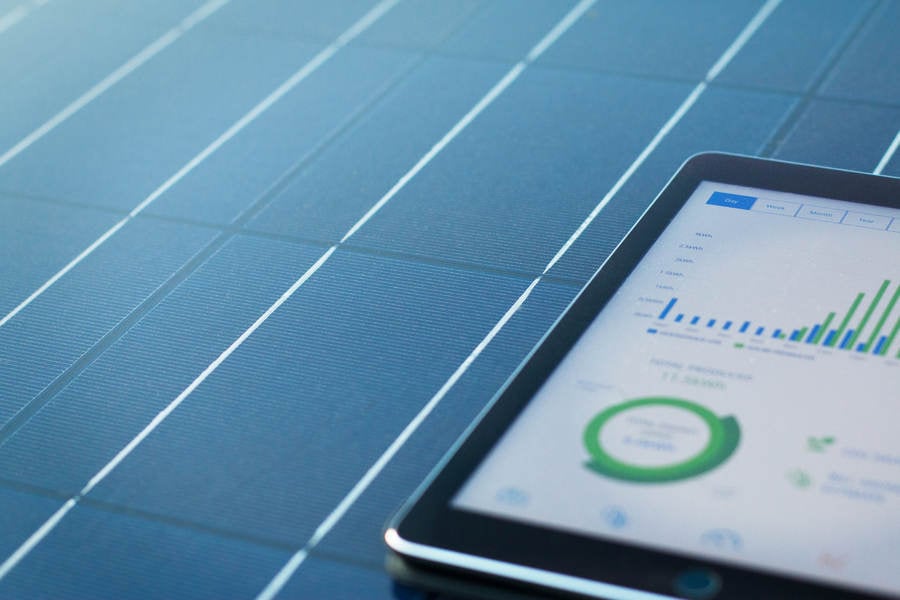 Solar Panel with Digital Tablet Showing Solar Energy Tracking App