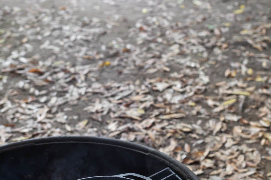 An Iron Skillet with Sizzling Bacon on a Fire Pit in a Campground
