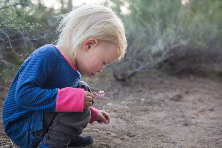 Toddler Girl Squatting Down on a Trail and Exploring Dirt 