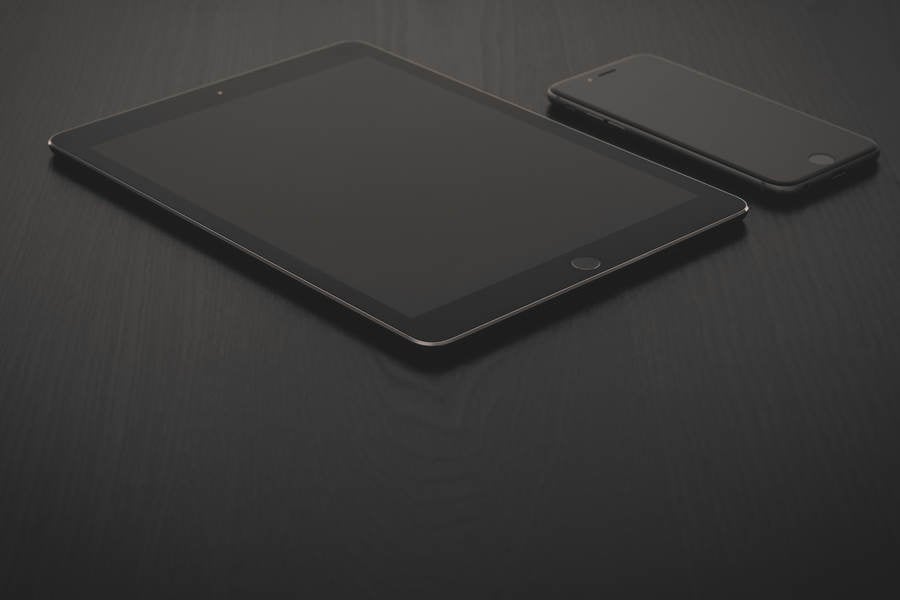 Detailed View of a Digital Tablet and Cell Phone on a Black Table