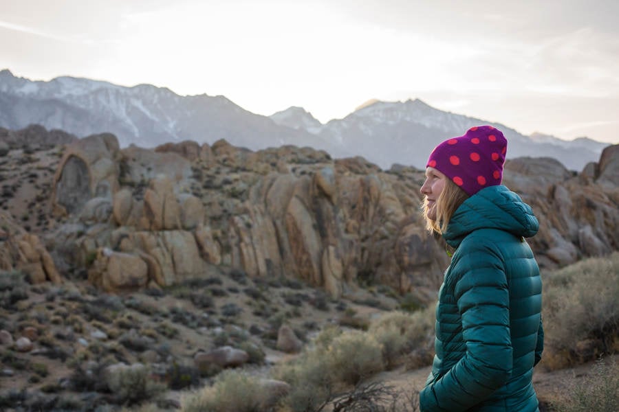Young Smiling Woman with a Beanie Looking at Mountains
