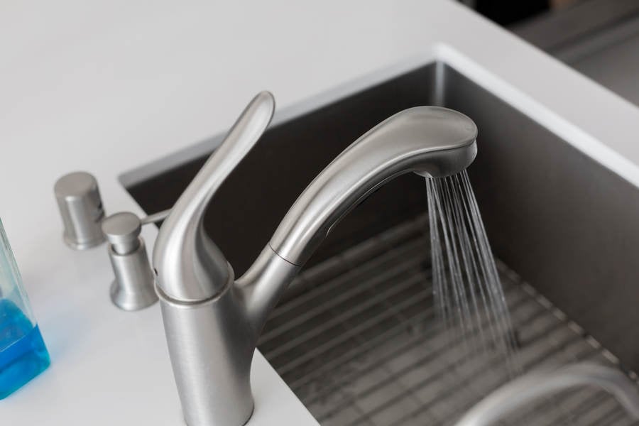 Close-Up of a Faucet with Running Water in a Modern Kitchen