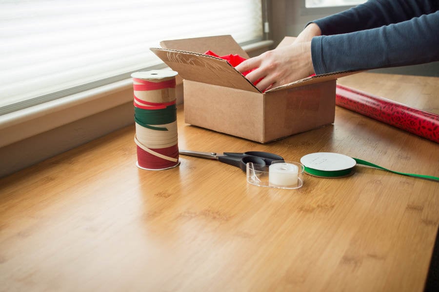 Woman Placing Christmas Present in a Box