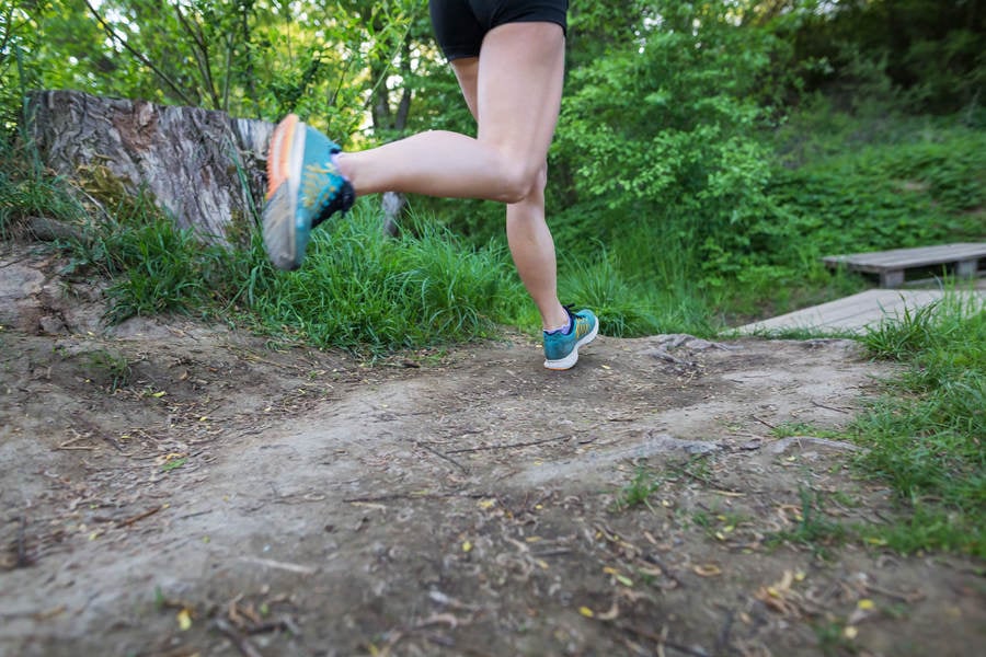 Low Section of an Athletic Woman Running on a Trail