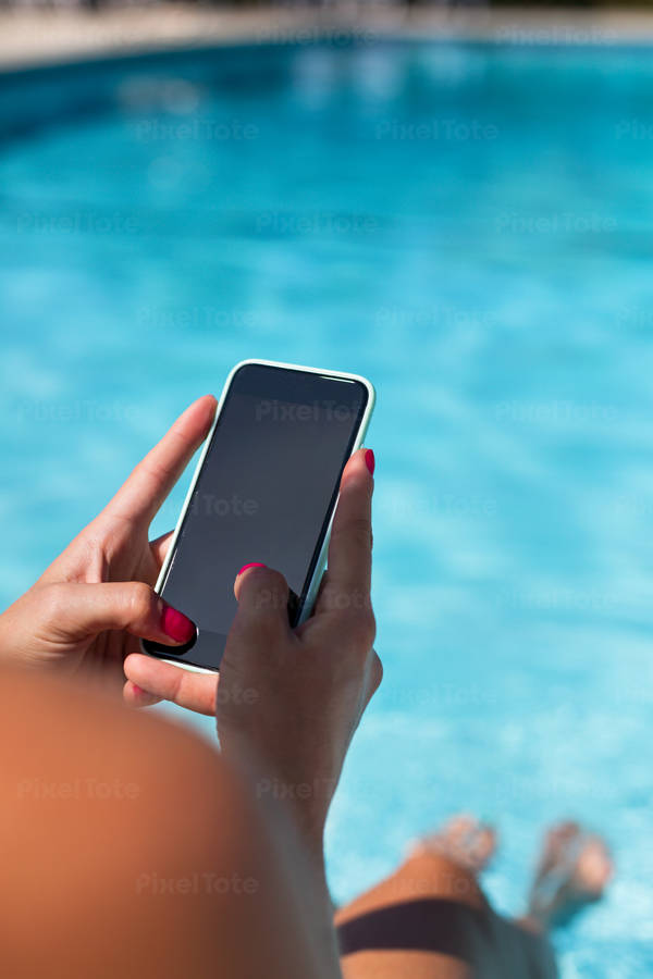Close-Up of a Woman Siting by Pool and Typing on a Smartphone