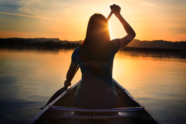 Rear View of a Girl Sitting in a Canoe Paddling