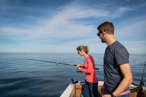 Young Couple Fishing from a Boat in a Calm Ocean