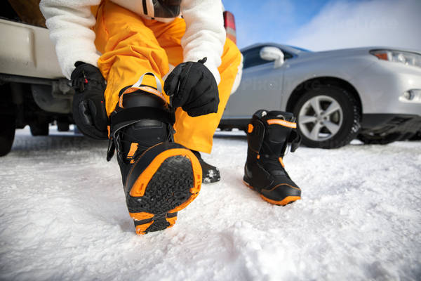 Low-Angle View of a Man Putting on Snowboarding Boots