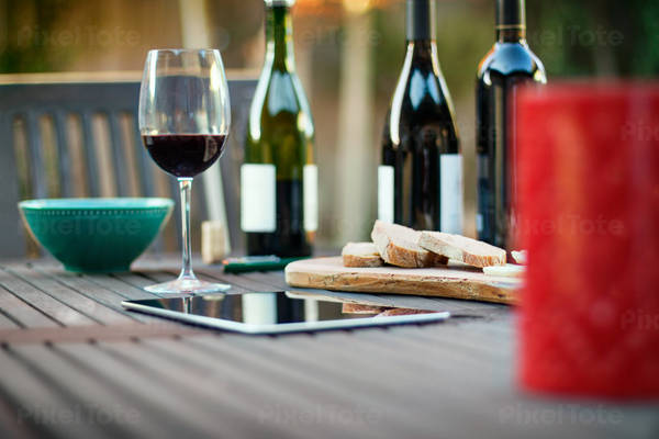 Table-Level View of Wine Bottles with Glasses and a Tablet